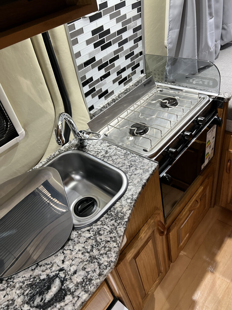 Detalle de cocina en motorhome Sprinter 316 con bacha y almacenamiento